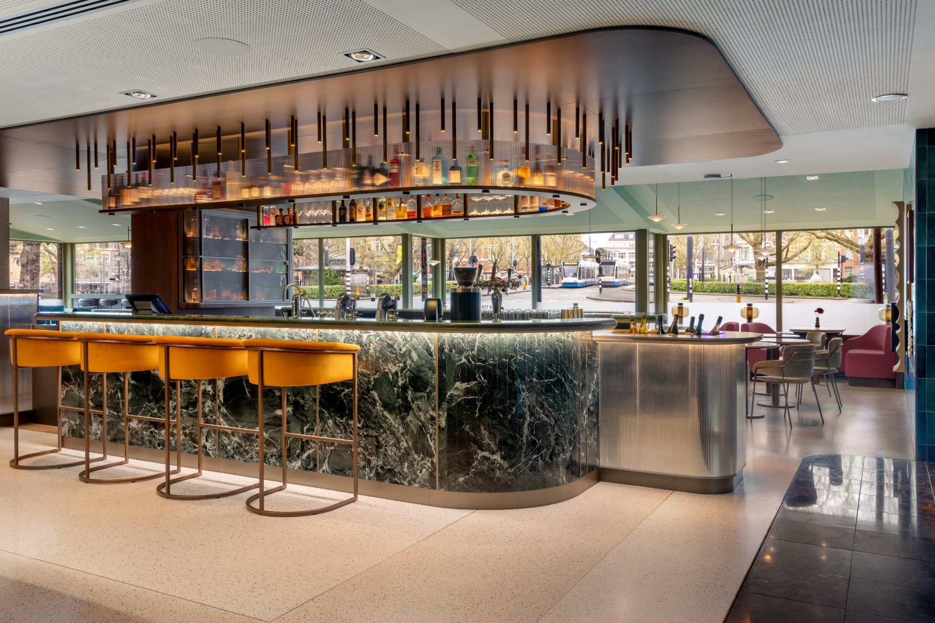 Bespoke bar with green marble, brass and velvet stools — Marriott Amsterdam